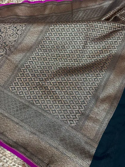 A full view of the black Banarasi silk saree, showing the contrast between the plain body and the heavily woven antique gold pallu.