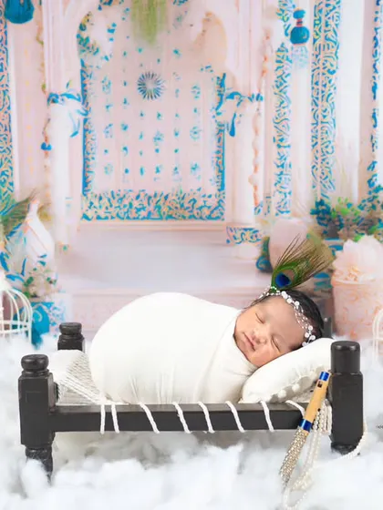 Another beautiful Krishna setup, with the baby sleeping on a miniature cot surrounded by peacock decor and fluffy clouds.