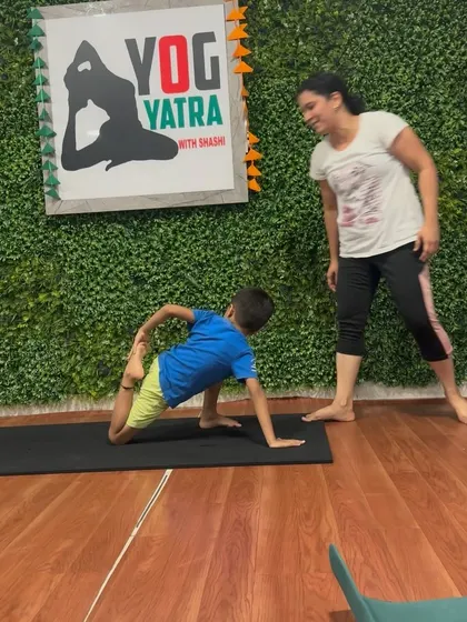 I love watching my students' progress. Here, I'm smiling as a young yogi masters a tricky backbend with grace.