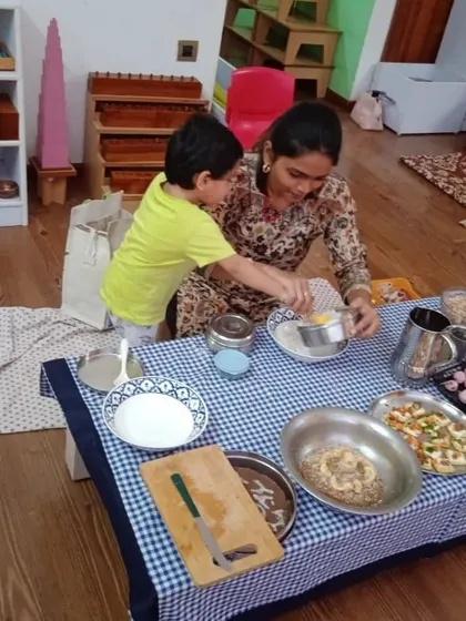 A child learns to measure and mix ingredients during our "Cooking without Fire" day. These are practical math and science lessons in a fun context.