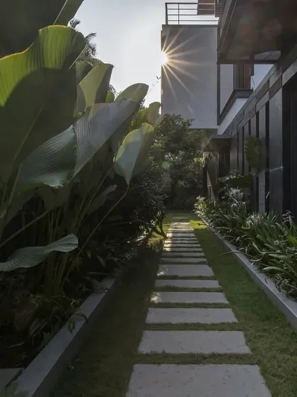 A landscaped stone pathway at the 'Mango Tree Yard' residence. We carefully designed the outdoor spaces to create a journey through the property, connecting the built form with the surrounding greenery and sunlight.