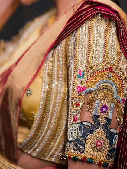 Detailing that tells a story. This close-up reveals the exquisite hand embroidery on a bridal blouse sleeve, featuring a majestic elephant motif, a symbol of royalty and strength. The intricate zardosi and threadwork are a testament to our dedication to heritage crafts.