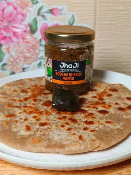 A tempting combination of a hot, flaky paratha topped with a piece of our Sookha Bharua Mango pickle. A classic and beloved pairing.