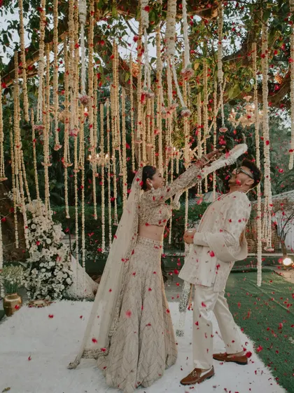 A fun and dynamic shot of the couple playfully exchanging garlands during their Varmala ceremony.