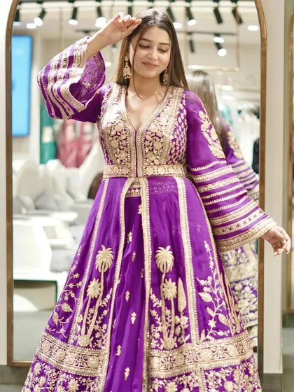 Regal reign! Make a majestic statement in this vibrant purple Anarkali with bell sleeves and intricate gold embroidery.