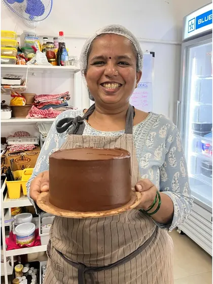 Look at Padma, getting fabulously good at this! She's holding a perfectly frosted chocolate cake, and I couldn't be prouder.