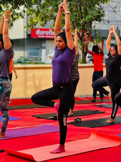Members hold the tree pose, a great asana for improving balance and stability, surrounded by the positive energy of the group.