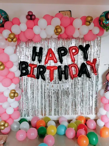 A simple Masha and the Bear theme for a home party, using a balloon arch against a shimmer curtain backdrop.