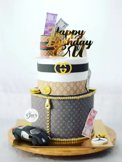 For the person who loves luxury, this two-tier cake is inspired by Gucci and Louis Vuitton. It features edible money, brand logos, and even a small sculpted car.