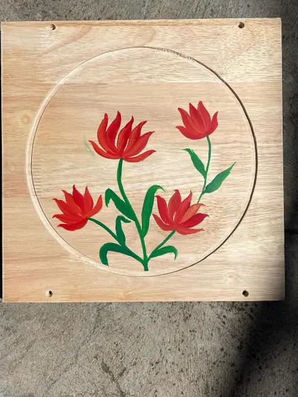 A set of four stylized red tulips painted on a light wood board. The simplicity of the design adds to its charm.
