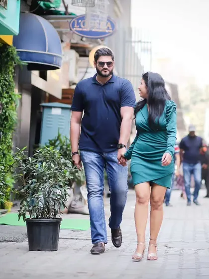A full-length shot of a couple walking hand-in-hand down a charming city street for their pre-wedding shoot. It feels natural and tells the story of them moving forward together.
