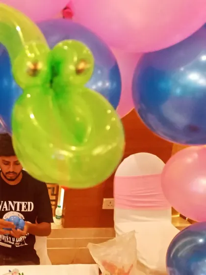 A balloon twisting artist at work during a birthday party. This is a great form of live entertainment that keeps children engaged and gives them a fun party favor to take home.
