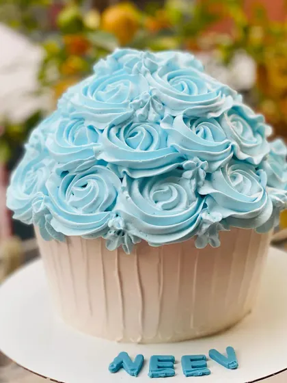 A giant cupcake smash cake, perfect for a fun and messy first birthday photoshoot.