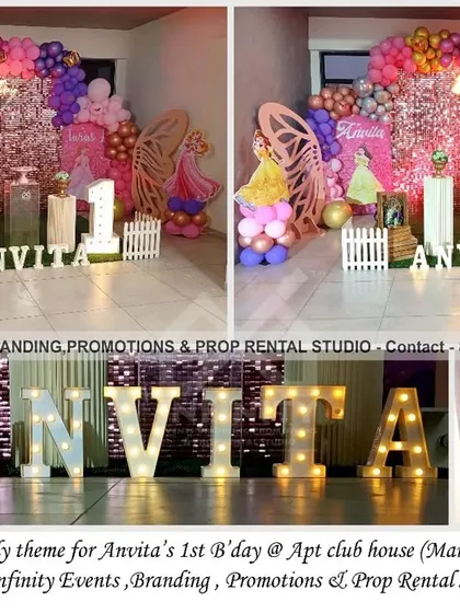 A popular combination of Princess and Butterfly themes for a first birthday. This setup features a rose gold sequin backdrop, a colorful balloon garland, large butterfly wing props, and acrylic tables for a modern and glamorous look.