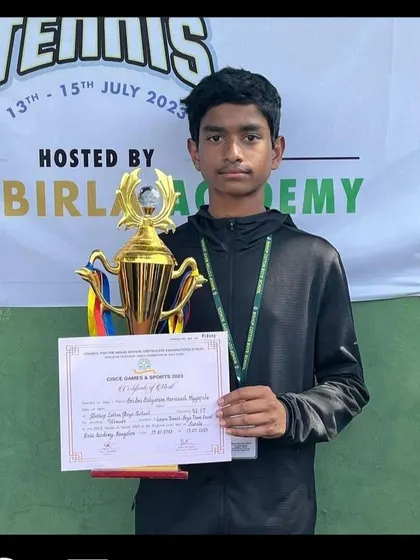 Harivansh proudly holds his singles trophy from the regional school games, a testament to his dedication.