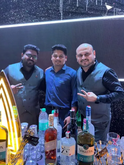 Our founder with two team members behind a modern, illuminated bar. We combine great leadership with a talented crew to deliver exceptional results.