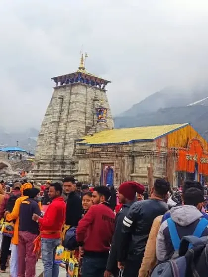 A candid shot of the crowd of pilgrims at Kedarnath, with the ancient temple standing tall amidst them. It shows the diverse mix of people united by their devotion.