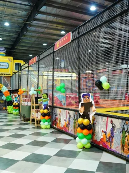 We brought the world of Minecraft to life for this birthday party, with pixelated character cutouts and a green, brown, and black balloon theme.