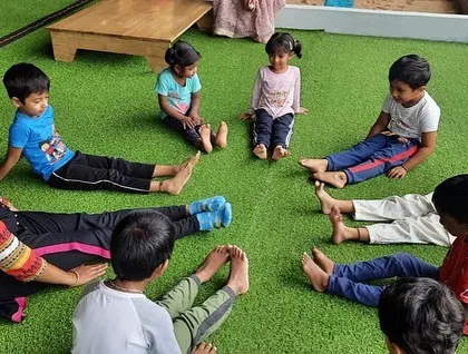 A teacher provides gentle guidance during a yoga session, ensuring each child feels supported.