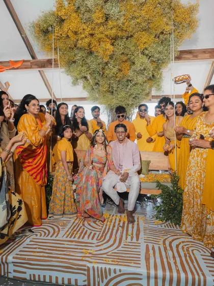 For a bride who dreamed of a Bali-themed Haldi, we transformed a lakeside venue in Wayanad. We created a magnificent tree of life centerpiece with yellow baby's breath and a traditional Balinese swing for the couple, all set against the stunning open views of Banasura lake.