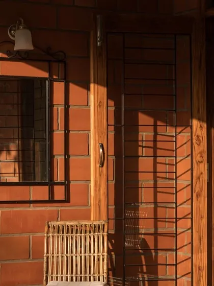Sunlight grazes an exposed brick wall at the Reshma Residence, highlighting its texture and color variations. This close-up shows how we use natural light to animate surfaces and create a warm, inviting ambiance.