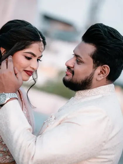 A tender moment where the groom gently caresses the bride's cheek. These are the candid, romantic shots that we specialize in.