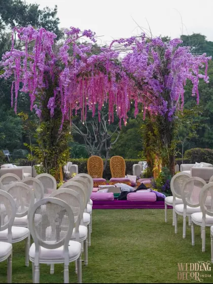 A ‘Lavender Dream’ mandap designed for an outdoor ceremony. The vibrant purple floral structure stands out beautifully against the green landscape, creating a romantic and unforgettable setting for the vows.
