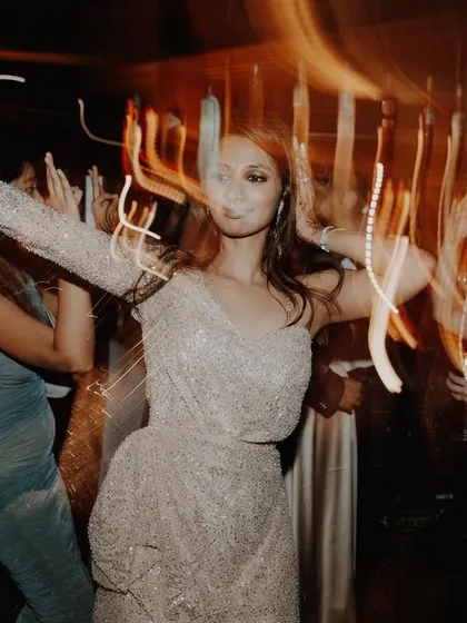 A cool, motion-blur shot of a guest dancing, the light trails creating a feeling of high energy and movement.