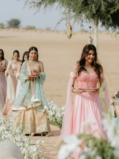 The bridesmaids making their entrance down the floral aisle at the beautiful desert wedding.