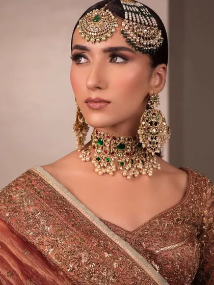 A traditional bridal look with a focus on intricate jewelry. You'll learn how to apply makeup that complements heavy jewelry, ensuring the overall look is balanced and not overwhelming.