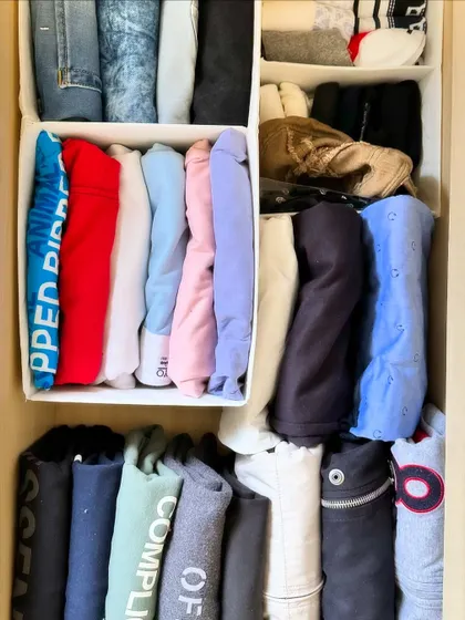 A close-up of perfectly file-folded sweatshirts and hoodies. Using drawer dividers helps keep categories separate and maintains the structure of your organized space.