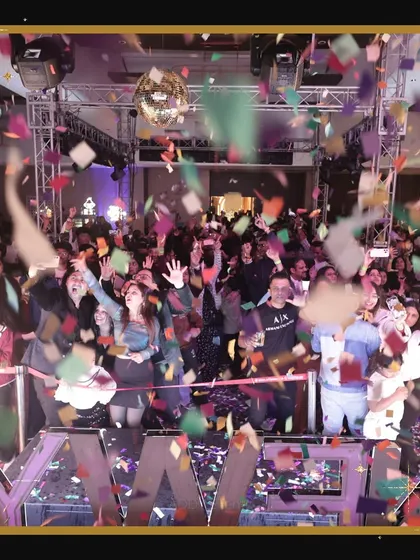 We create events where guests feel completely immersed in the celebration. This photo shows the crowd at our New Year's Eve party enjoying the music and confetti drop at the stroke of midnight.