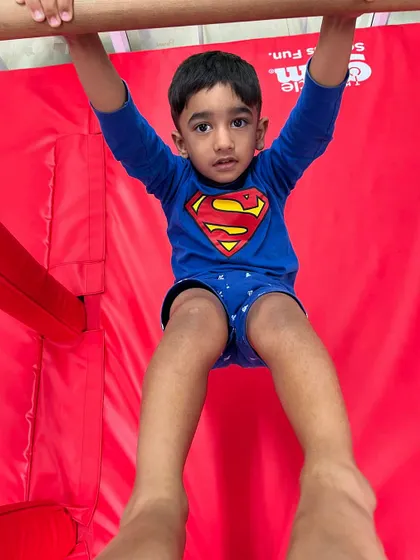 This young man is building serious strength and focus as he hangs from the bar. Each second he holds on, he's building resilience and determination.