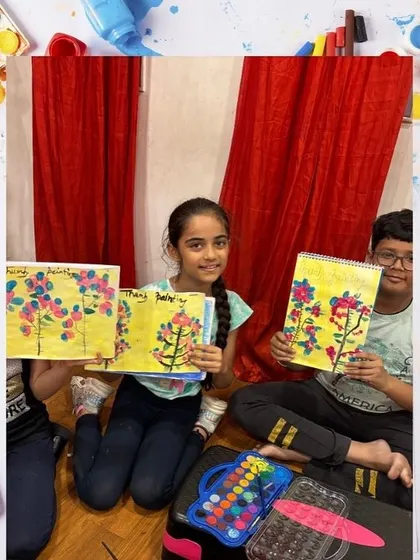 Students show off their beautiful thumbprint cherry blossom trees. This is a fun, tactile project that teaches them about color and composition.