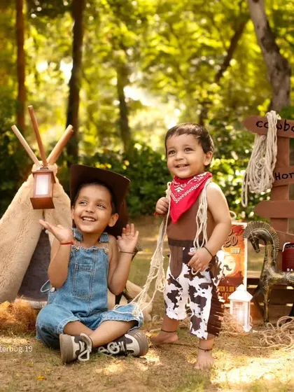 Two happy cowboys, a boy and his younger sibling, enjoying an outdoor adventure shoot together.