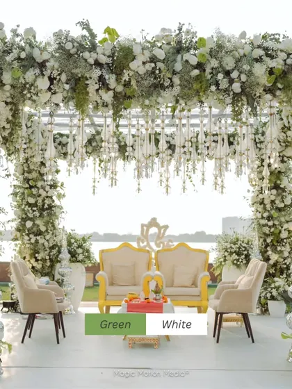 A serene green and white mandap set against a tranquil waterfront. The abundance of baby's breath and white roses created an ethereal atmosphere, perfect for a daytime wedding ceremony.