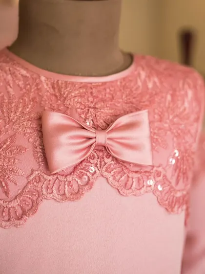 The details are where the magic happens. This close-up shows the intricate lace work and delicate sequins I use on a bodice, finished with a perfectly tied satin bow to complete the look.