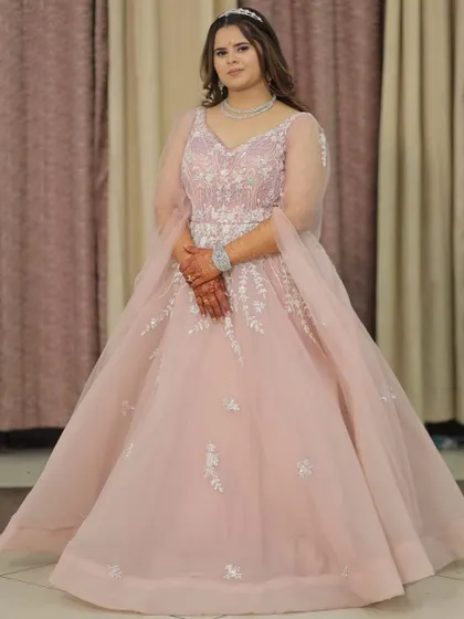 Feel like a princess in this beautiful pastel pink ball gown. With delicate silver embroidery on the bodice and sheer sleeves, this rental gown is a fantastic choice for an engagement, reception, or a pre-wedding photoshoot.