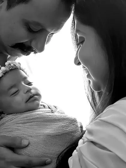 An intimate close-up of new parents with their baby. Black and white photography is perfect for these quiet, emotional moments.