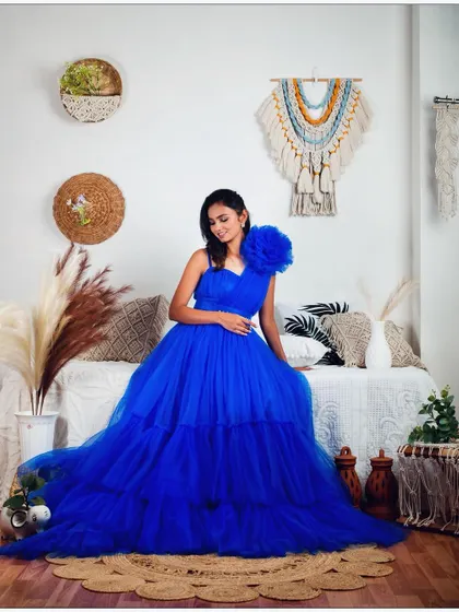 The royal blue gown looks stunning in this bohemian-style studio setup.