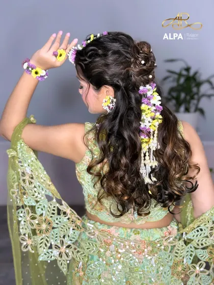The complete look from the back, showing how the floral hairpiece cascades down the curly hair.