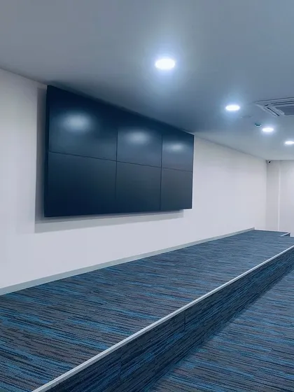 A large video wall installed in the TVS Auction Centre. This technology is central to the auction process, and we designed the surrounding space with tiered flooring and optimal acoustics to enhance the viewing experience.