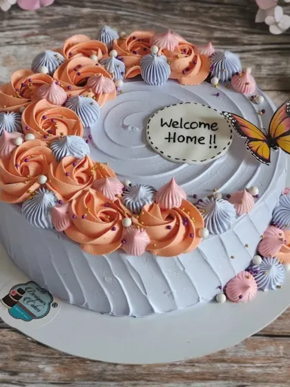 A "Welcome Home" cake with a beautiful arrangement of peach and lavender rosettes. It's a warm and sweet way to greet a loved one.