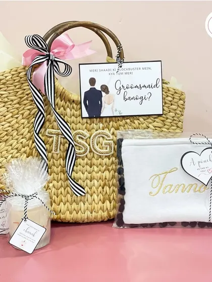 A complete bridesmaid proposal hamper in a personalized jute bag, including a custom candle, a personalized pouch, and a "Will you be my Groomsmaid?" card.