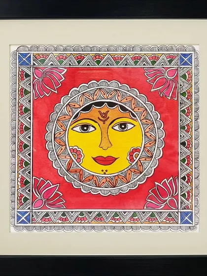A vibrant depiction of the sun in Madhubani style by Anu Bansal. The use of bright red and yellow, along with lotus motifs, gives this traditional artwork a warm and auspicious feeling.