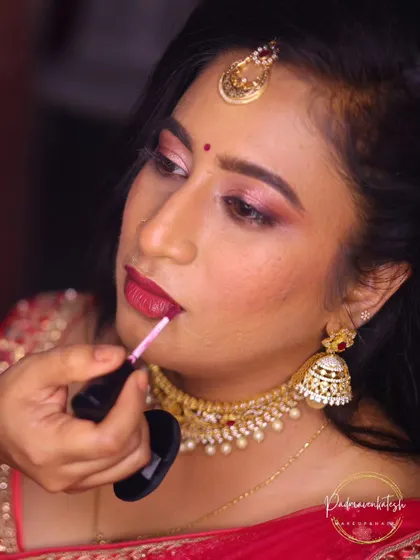 The final touch. Applying a long-lasting liquid lipstick to ensure the bride's lip color stays perfect through all the smiles, sips, and celebrations of the evening.