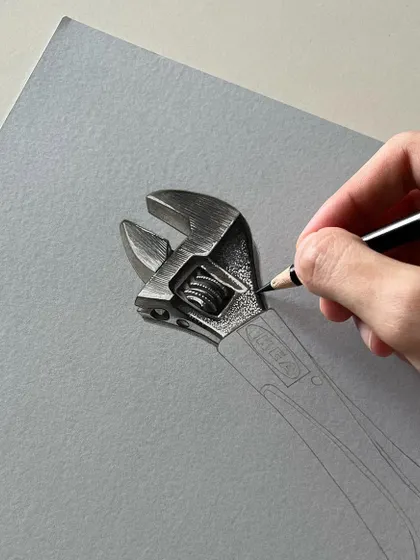 A work-in-progress shot of a wrench drawing. I am using a black pencil to carefully render the texture and form of the adjustable jaw, paying close attention to the small details.