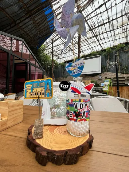 Another unique centerpiece with a paper pinwheel, a mini airplane, and a sign for Spain, continuing the global journey.