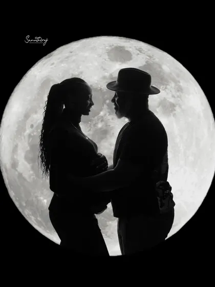 A romantic silhouette of a couple against a full moon. This classic and dramatic shot is a beautiful way to capture the love and anticipation of expecting parents.