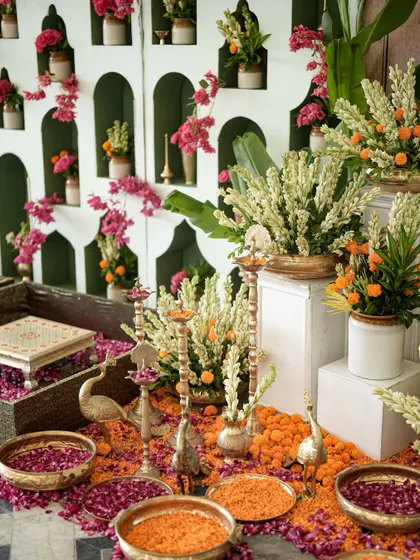A beautiful arrangement for the haldi, with traditional brass lamps, peacock figurines, and a mix of marigolds and tuberoses, reflecting both North and South Indian traditions.